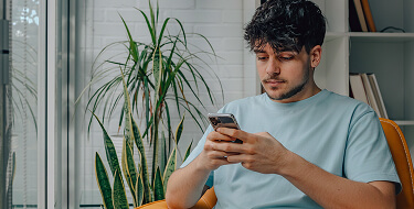 Man using phone for virtual dermatology appointment
