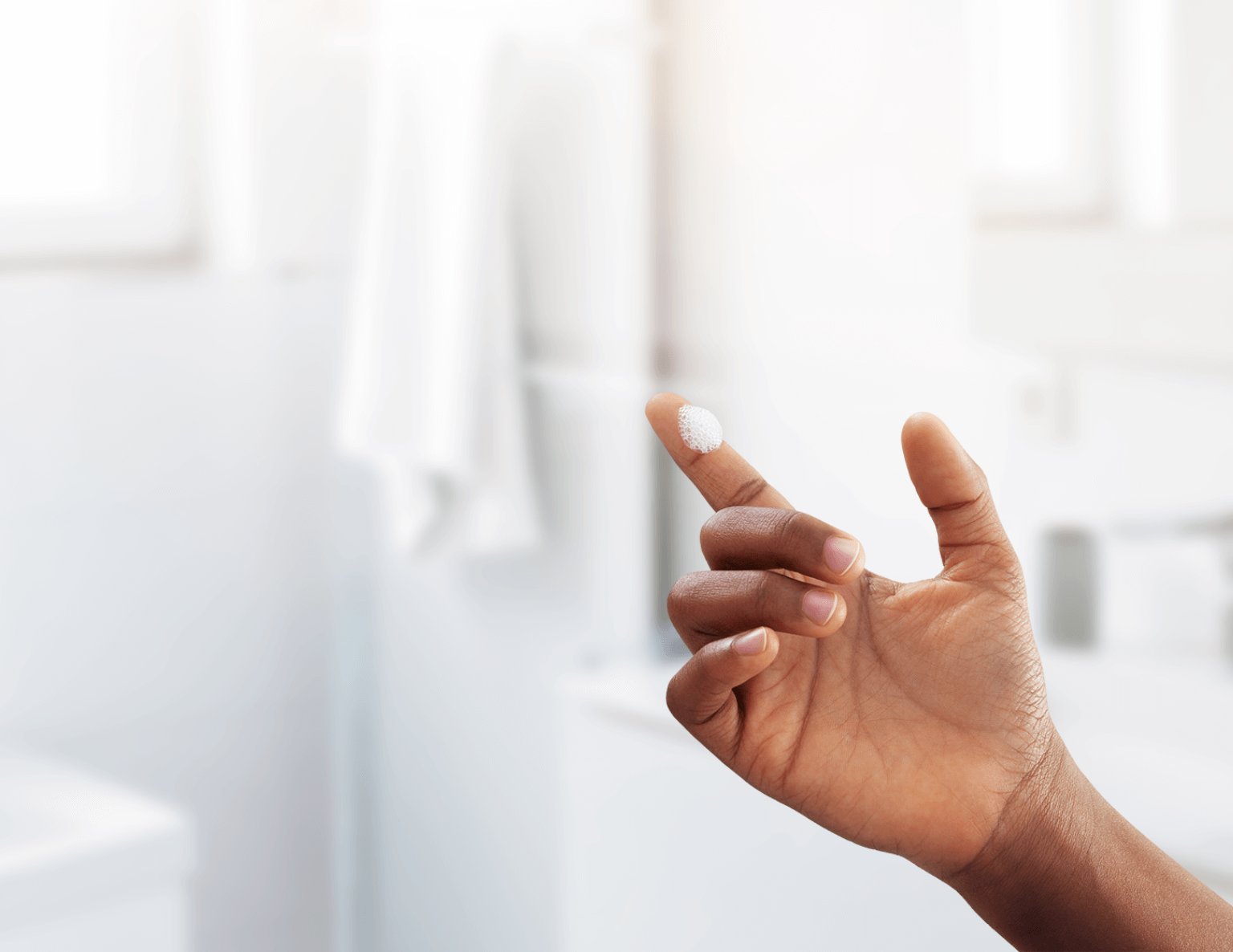 Hand with small pile of ZORYVE foam on finger